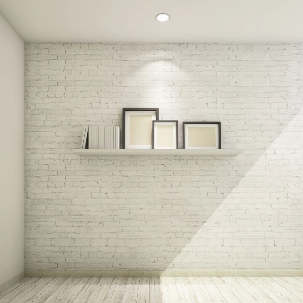 Set of blank photo frames on a shelf against the brick wall
