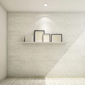 Set of blank photo frames on a shelf against the brick wall